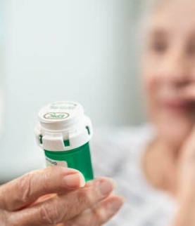 elderly patient holding Rx pill bottle